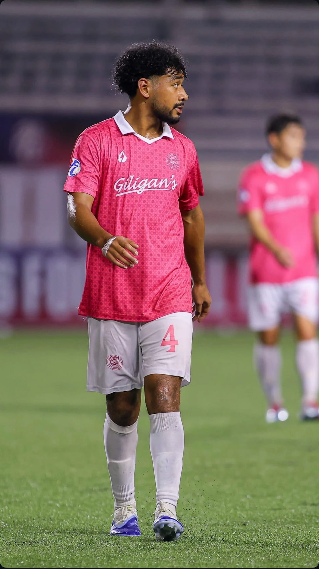 Nico playing professional soccer in a pink jersey